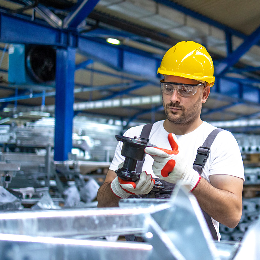 Factory worker inspecting a manufactured part