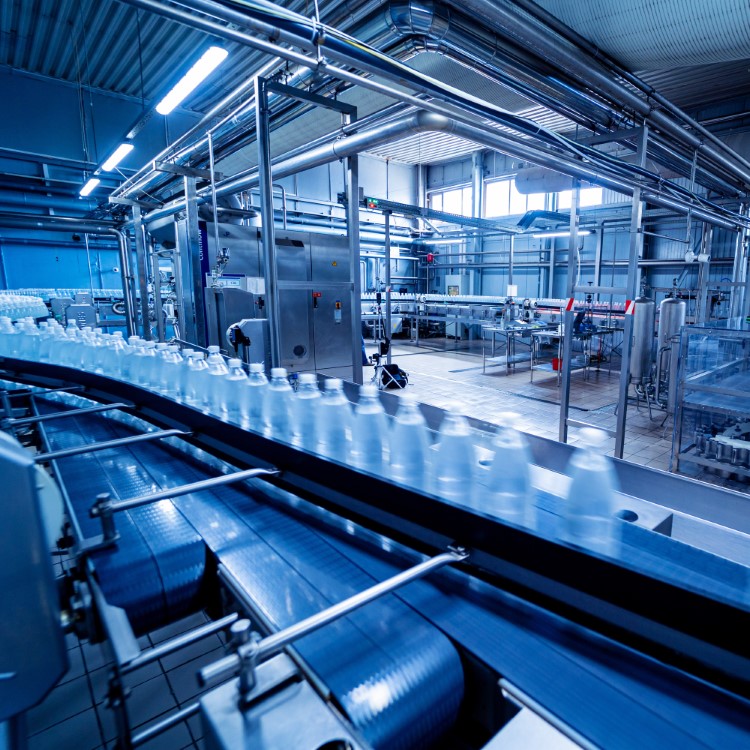 Conveyor belt with bottles of drinking water at a modern beverage plant.