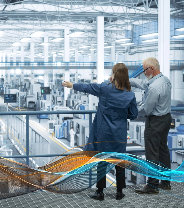 Factory employees pointing at autonomous manufacturing equipment