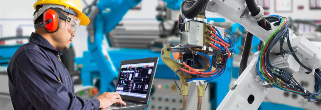 Engineer checks the status of a robot arm in an automation system.